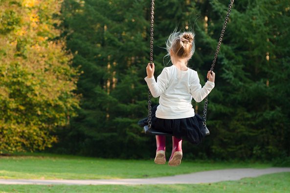 Niña de espaldas en un columpio en el parque, imagen de la terapia para el acoso escolar en Zaragoza