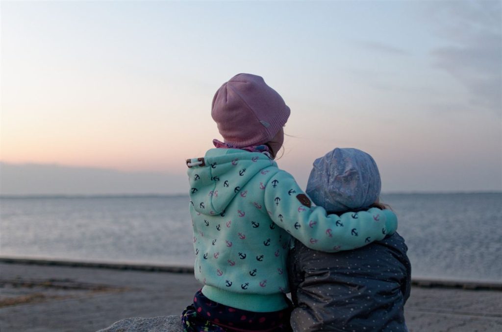 Dos niños de espaldas mirando el mar, imagen de la psicología infantil en Zaragoza