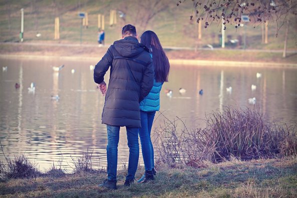 Pareja de espaldas junto a un lago, imagen de la terapia de pareja en Zaragoza